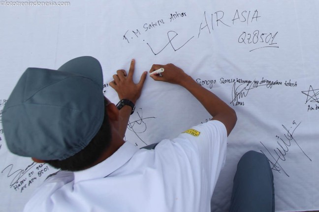 Seorang siswa membubuhkan tanda tangan untuk korban kecelakaan AirAsia QZ 8501 di SMA Negeri 2 Medan, Sumut, Senin (5/1). Ratusan siswa menggelar doa bersama dan aksi seribu tanda tangan sebagai bentuk kepedulian dan belasungkawa atas jatuhnya pesawat AirAsia. ANTARA FOTO/Septianda Perdana/Rei/ama/15.